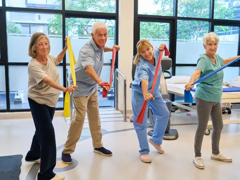 Personas mayores realizando ejercicios físicos al aire libre, promoviendo la salud física y el bienestar