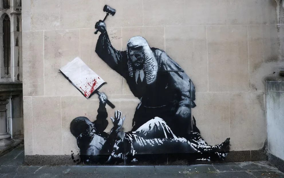 Mural de Banksy en la fachada del Tribunal Superior de Londres que fue borrado en 2025 | Foto: REUTERS / Toby Melville