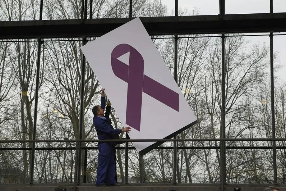 Operarios del ministerio de Sanidad colocan un lazo contra la violencia machista|Foto: EFE/Víctor Lerena El Defensor del Pueblo pide a Interior proteger la ubicación de las víctimas de violencia machista