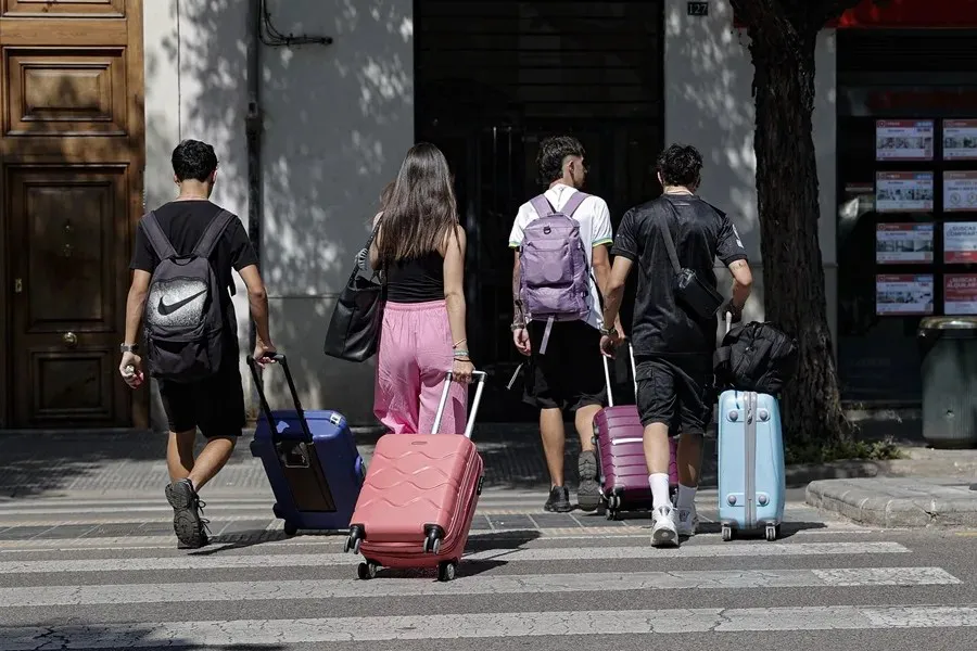 Un grupo de jóvenes camina con sus maletas por una calle de València|Foto: EFE/Manuel Bruque