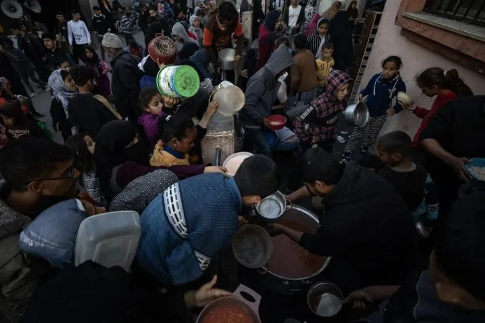 Reparto de comida para desplazados palestinos en un campamento en Rafah|Foto: EFE/EPA/Haitham Imad