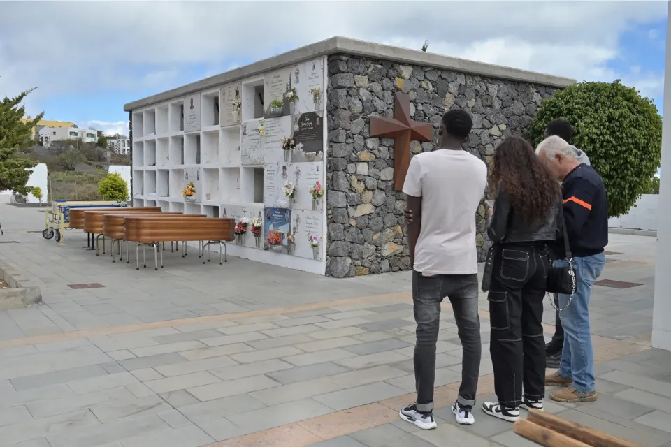 Personas observando urnas con pertenencias de migrantes fallecidos en rutas marítimas hacia España | Foto: EFE