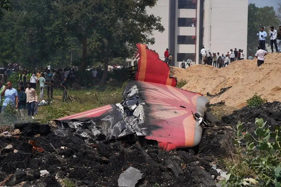 Personas junto a los escombros en el lugar del accidente aéreo en India|Foto: EFE/EPA/Sissharaj Solanki
